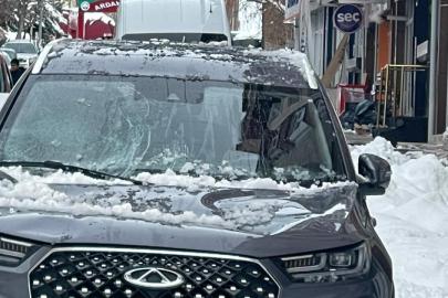 Park halindeki otomobilin üzerine kar ve buz kütlesi düştü